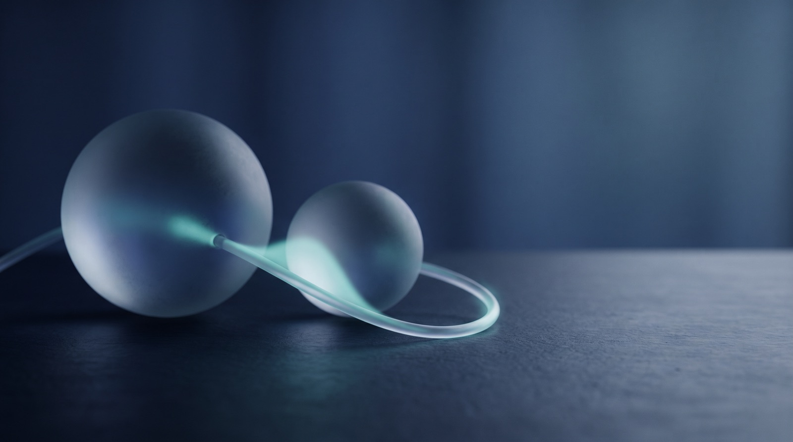 A large and a small frosted glass sphere joined by a looping tube of pale teal light
